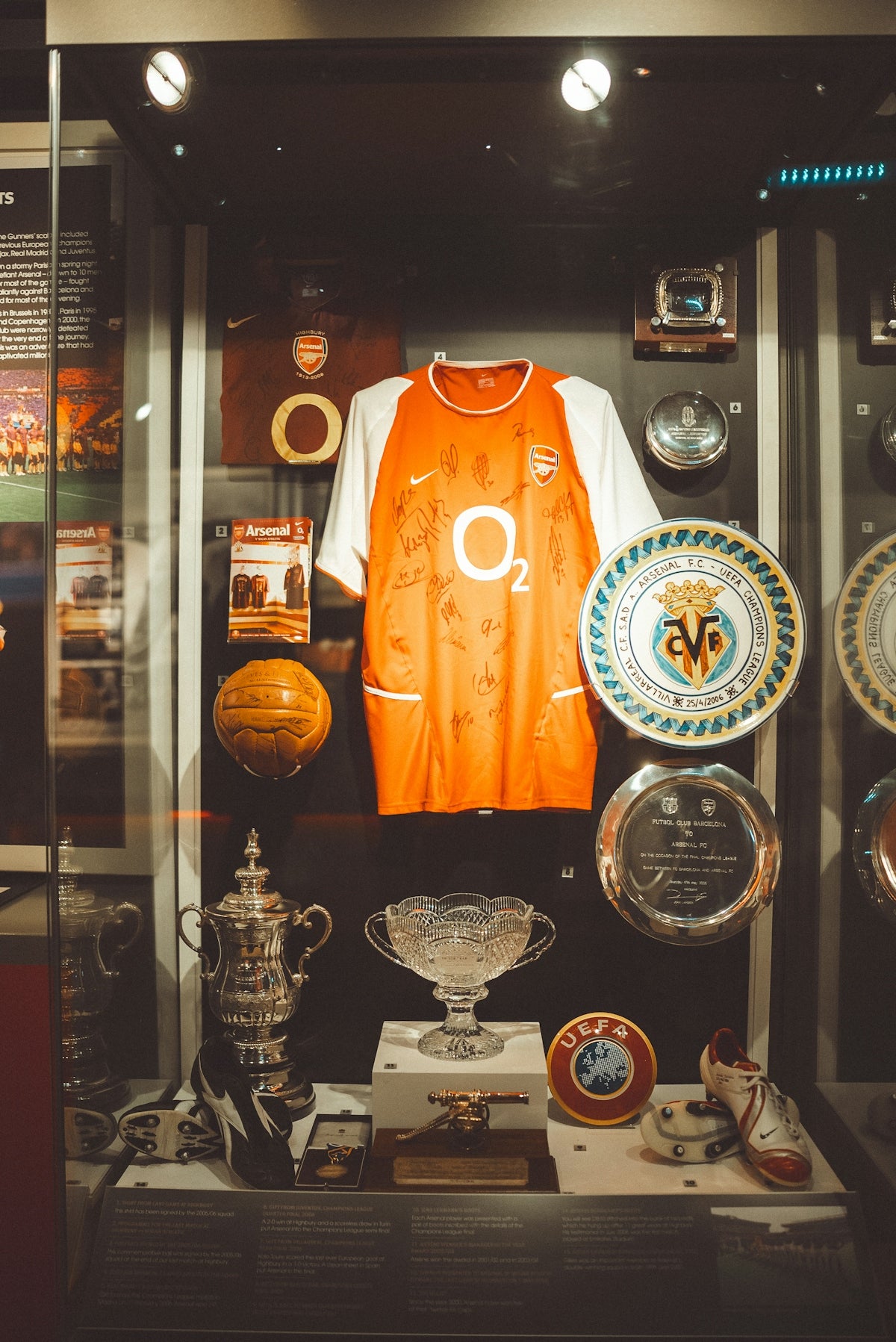 Arsenal football memorabilia displayed in a glass case.