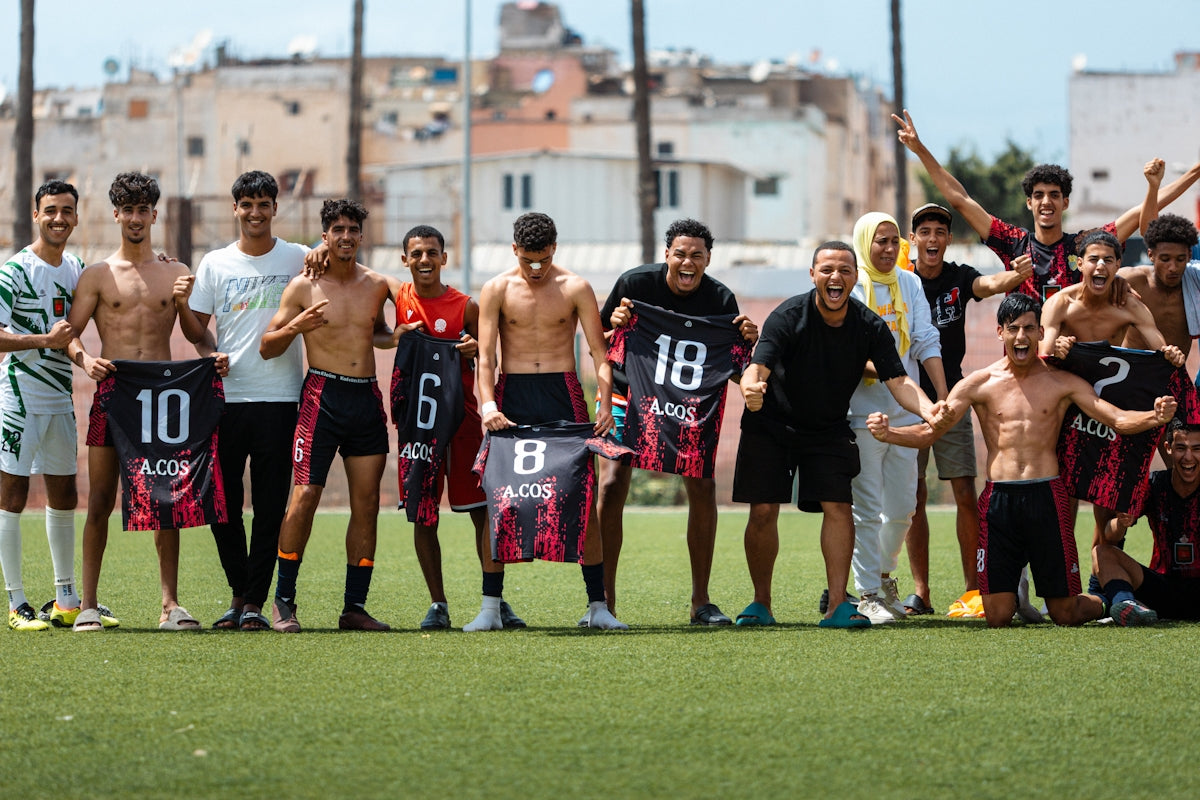 Soccer team posing shirtless with jerseys.